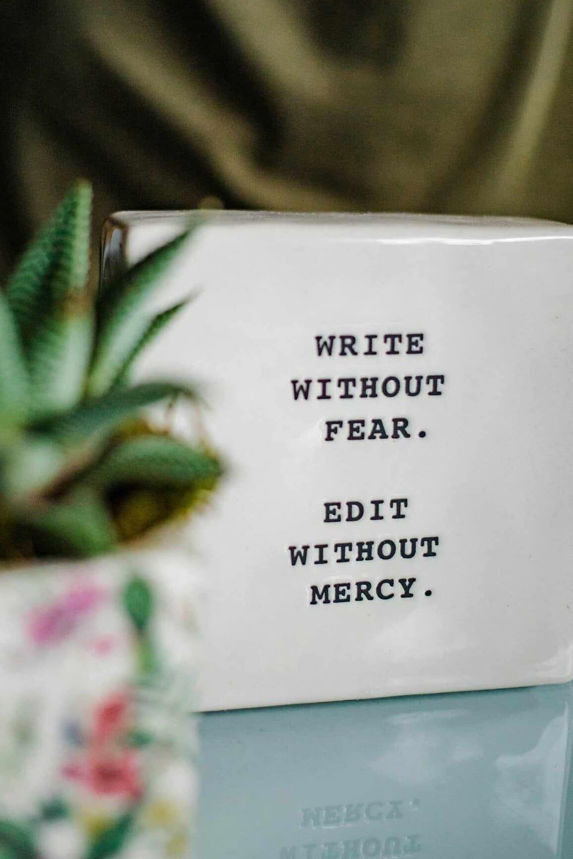 a-white-box-with-writing-on-it-next-to-a-plant 